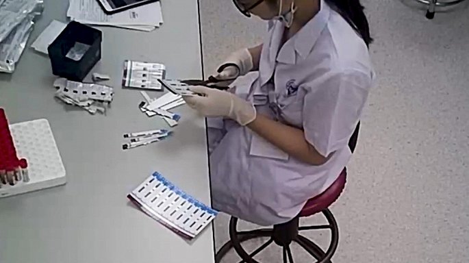 Hình ảnh kỹ thuật viên cắt đôi que thử xét nghiệm HIV và viêm gan B1